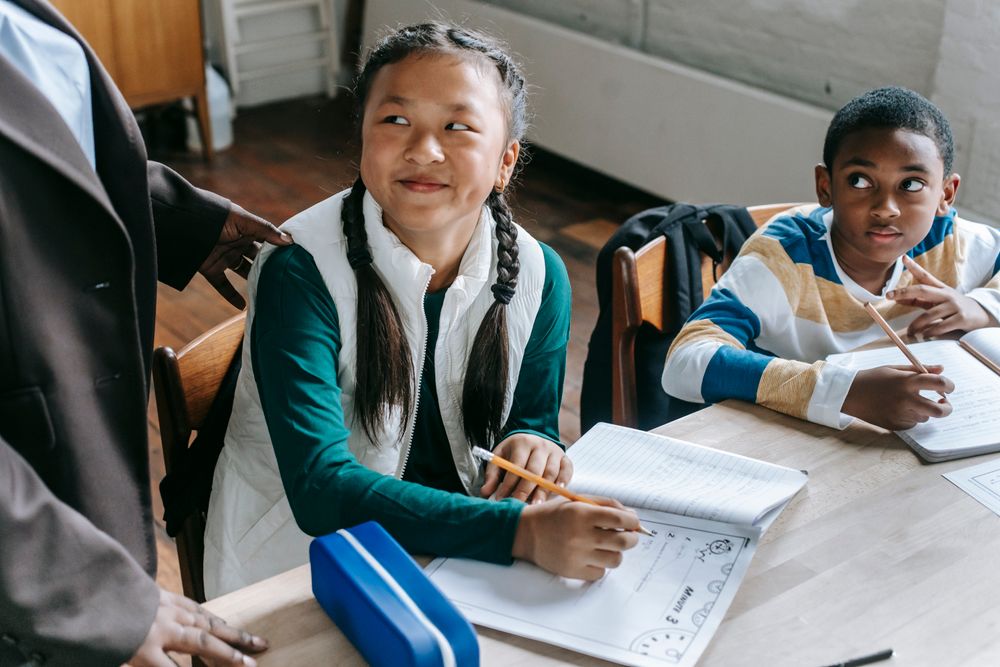 School-age students working together with books and worksheets